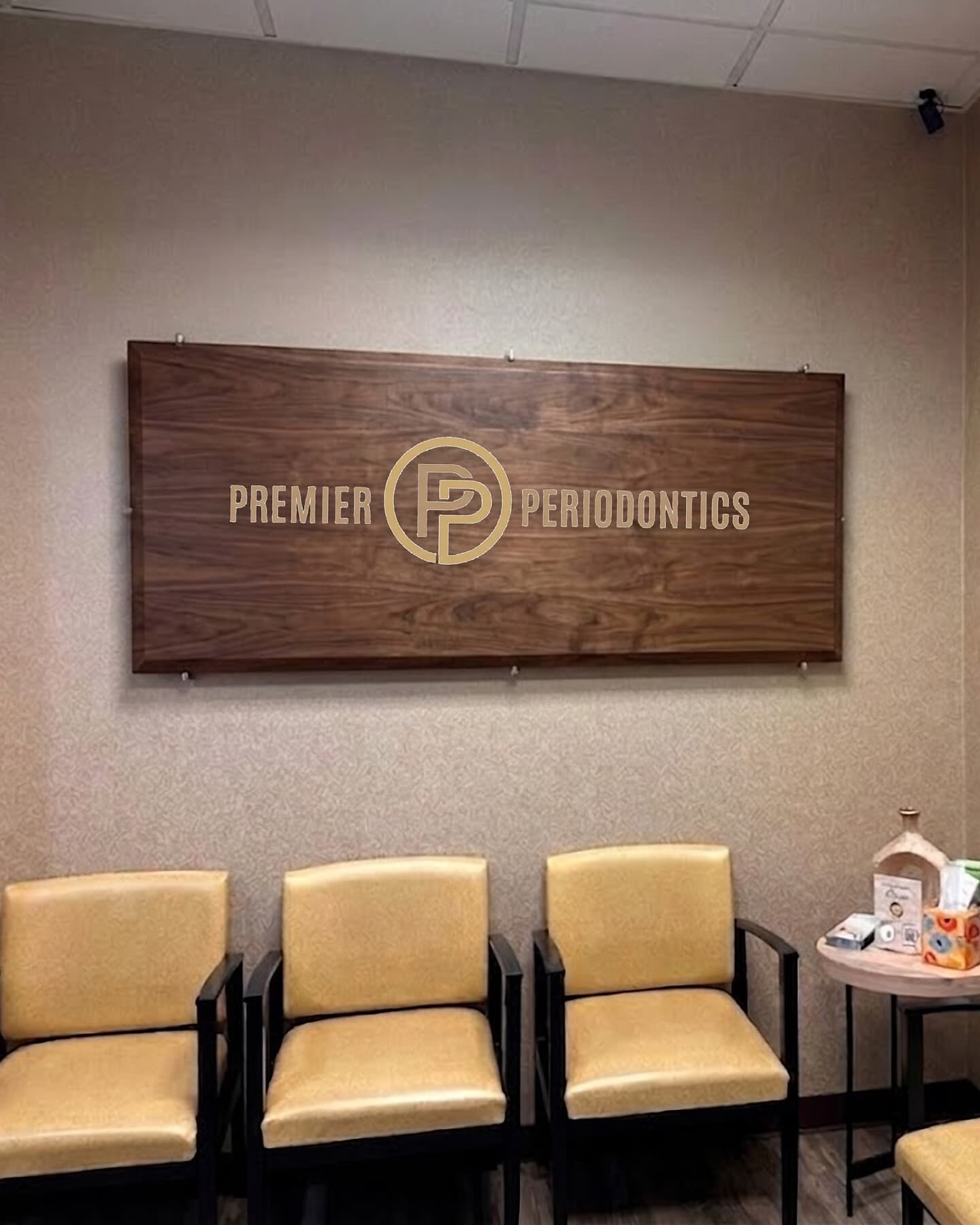 The Premier Periodontics reception, with the practice mark on the wall
